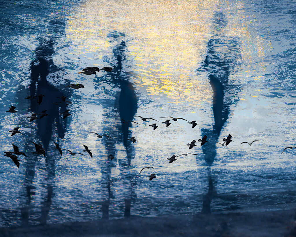 Three children greeting the sun on the beach in the morning
